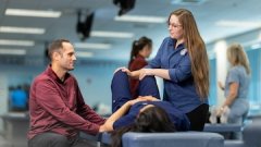 Osteopathic students practice patient assessment techniques in a classroom-style clinical setting.