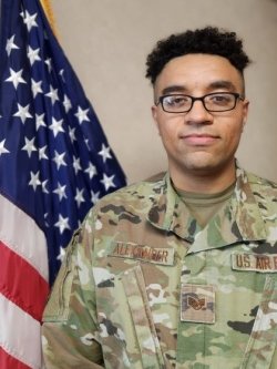 Andre Alexander poses in military uniform with flag
