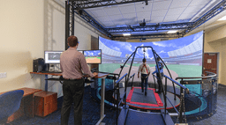 Men using the CAREN system with a virtual display of a baseball field.
