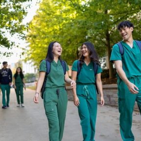 students wearing scrubs  walking on IL campus