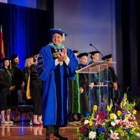 Dr. Joshua Baker on stage for graduation ceremony