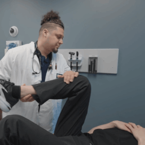 PA student Alex Quesada examines patient's leg.