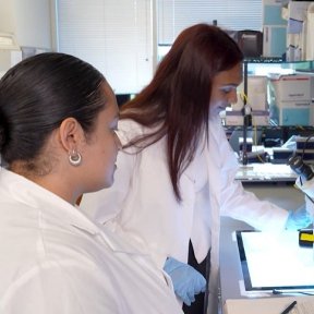 Oveyaa Vignesh, MBS alumnus, uses microscope in research lab.