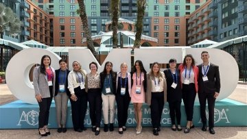 Chicago College of Osteopathic Medicine students gathered in front of the sign at the American Osteopathic Association’s (AOA) OMED conference.