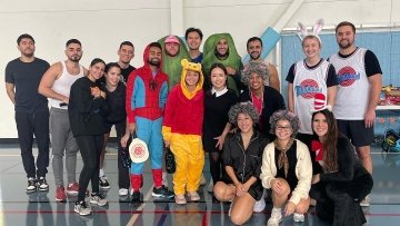 Pickleball tournament players gather for a photo, some with Halloween costumes.