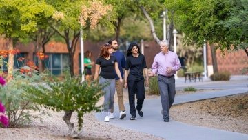 Group of 4 people walk outside at the Midwestern University Glendale campus.