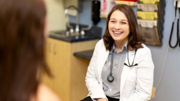 Dr. Kamrie Wolf smiles at a patient in the Student Health Clinic