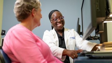 MWU Clinics optometrist shows low vision technology aid to patient.