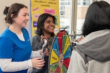 Students spin trivia wheel about Women's History Month.