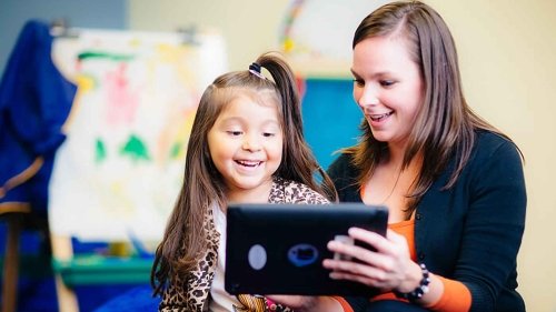 Child learning to read on an tablet.