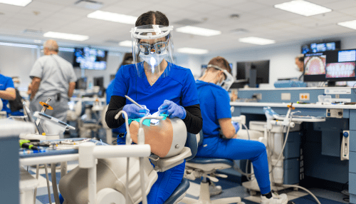 Student in dental simulation lab, working on fake patient