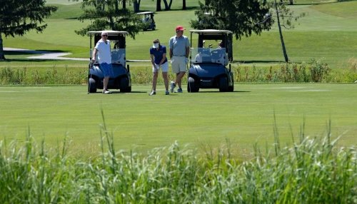 Attendees play golf and drive the golf carts.