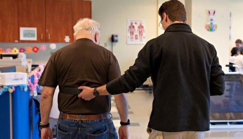 Student assists elderly man walking