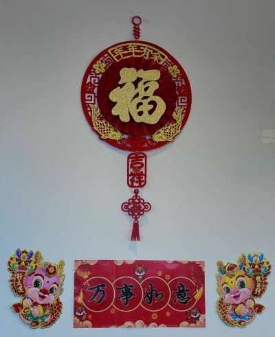Lunar new year decorations with red and gold colors and lucky symbols hang on the wall..