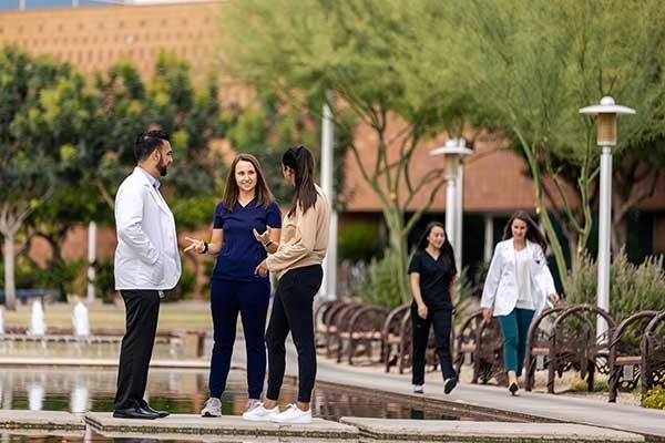Midwestern students chatting outside the front of the Glendale campus