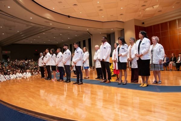 Students receive their white coats.