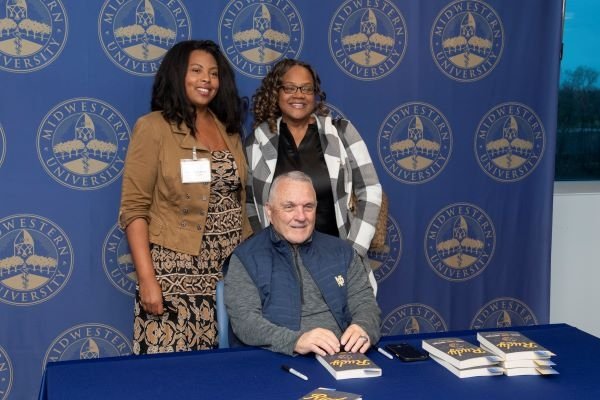 Rudy Ruettiger autographs his book for attendees.