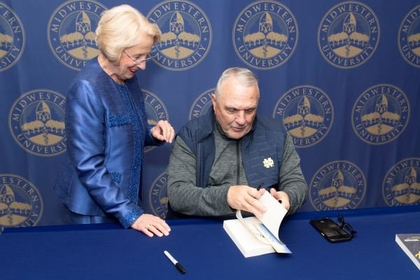 Rudy Ruettiger autographs his book for Dr. Goeppinger.
