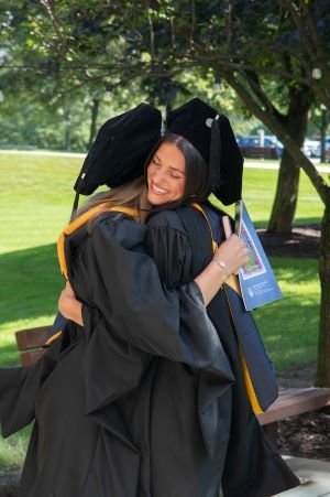 Graduates from the College of Health Sciences hug after ceremony