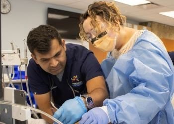Teacher assists student in dental lab.
