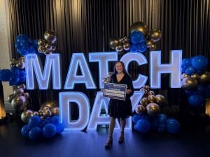 Student holds up match day sign