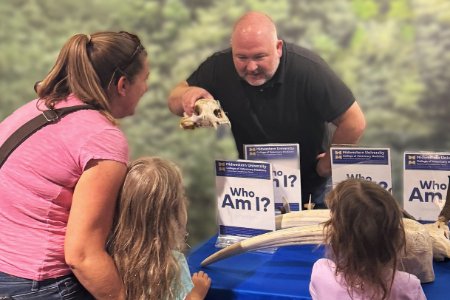 Kevin Manfredi shows children an animal skull at the Arizona Museum of Natural History
