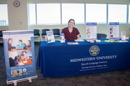 Students sits at information table.