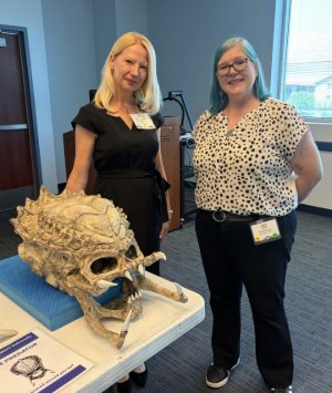 Dr. Smith stands next to summit participant and a 3D-printed realistic skull from the movie 'Predator'