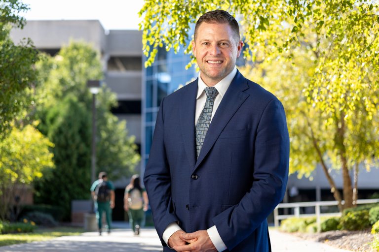 Dr. Baker with background of Midwestern University Downers Grove, IL and Glendale, AZ campuses.