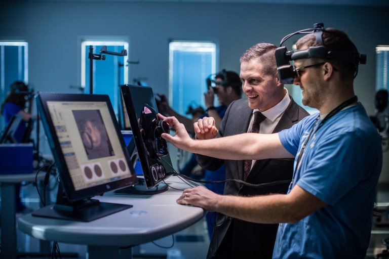 Dr. Baker works with students in the Optometry Virtual Reality lab.